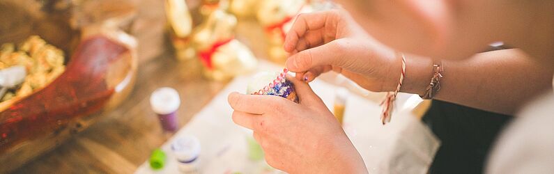 Kind bemalt ein Osterei